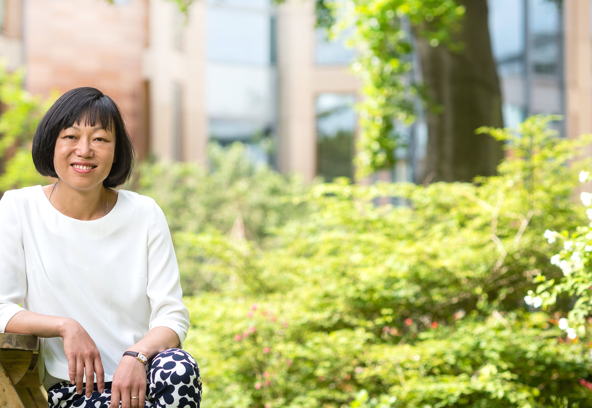 Bo Hu sits outside the University of Oxford China Centre in the gardens of St Hugh’s College