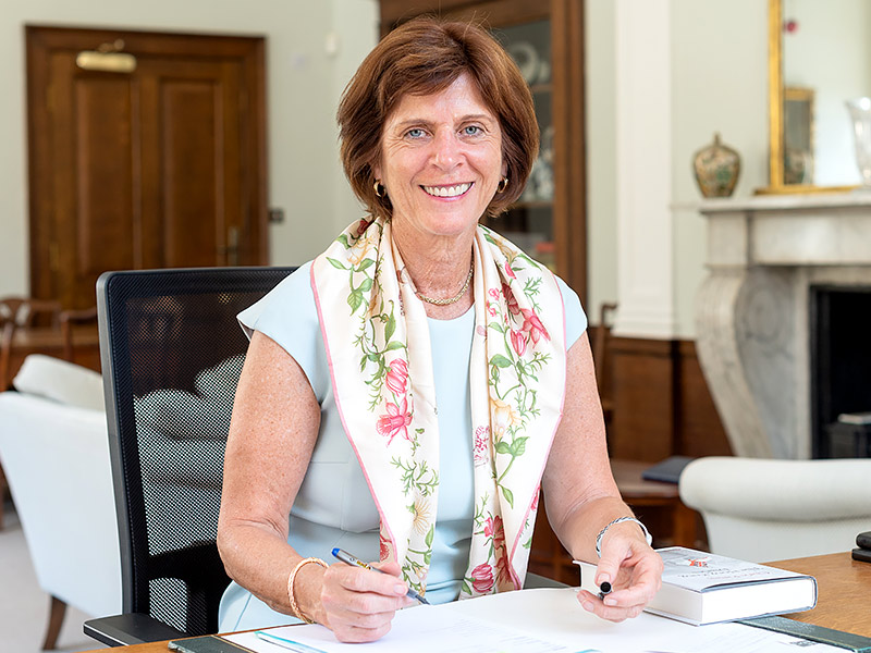 Professor Dame Louise Richardson sits behind a desk in her office.