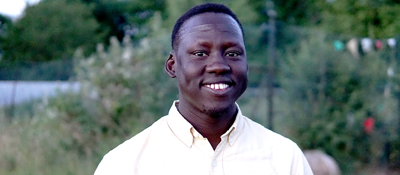 Lam Joar stands in verdant setting next to a body of water