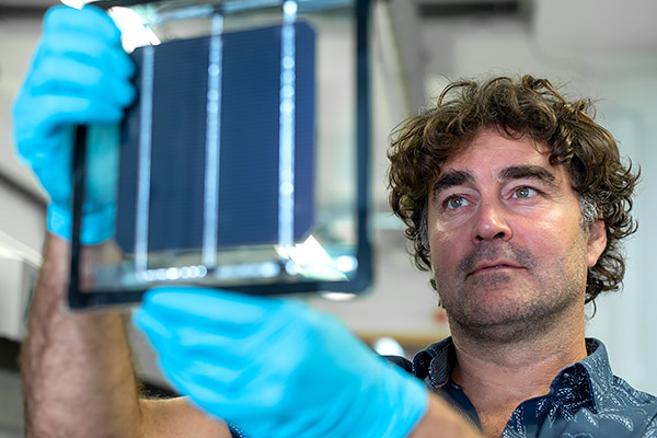 Professor Henry Snaith holds up a perovskite solar cell