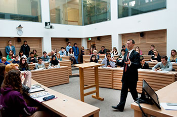 Photo of lecturer teaching in a classroom full of students