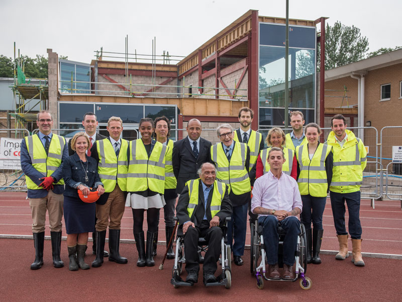 Percy Lewis and Henry Dean (centre) surrounded by family and friends in front of the facility that will bear their name. Photo credit: John Cairns.