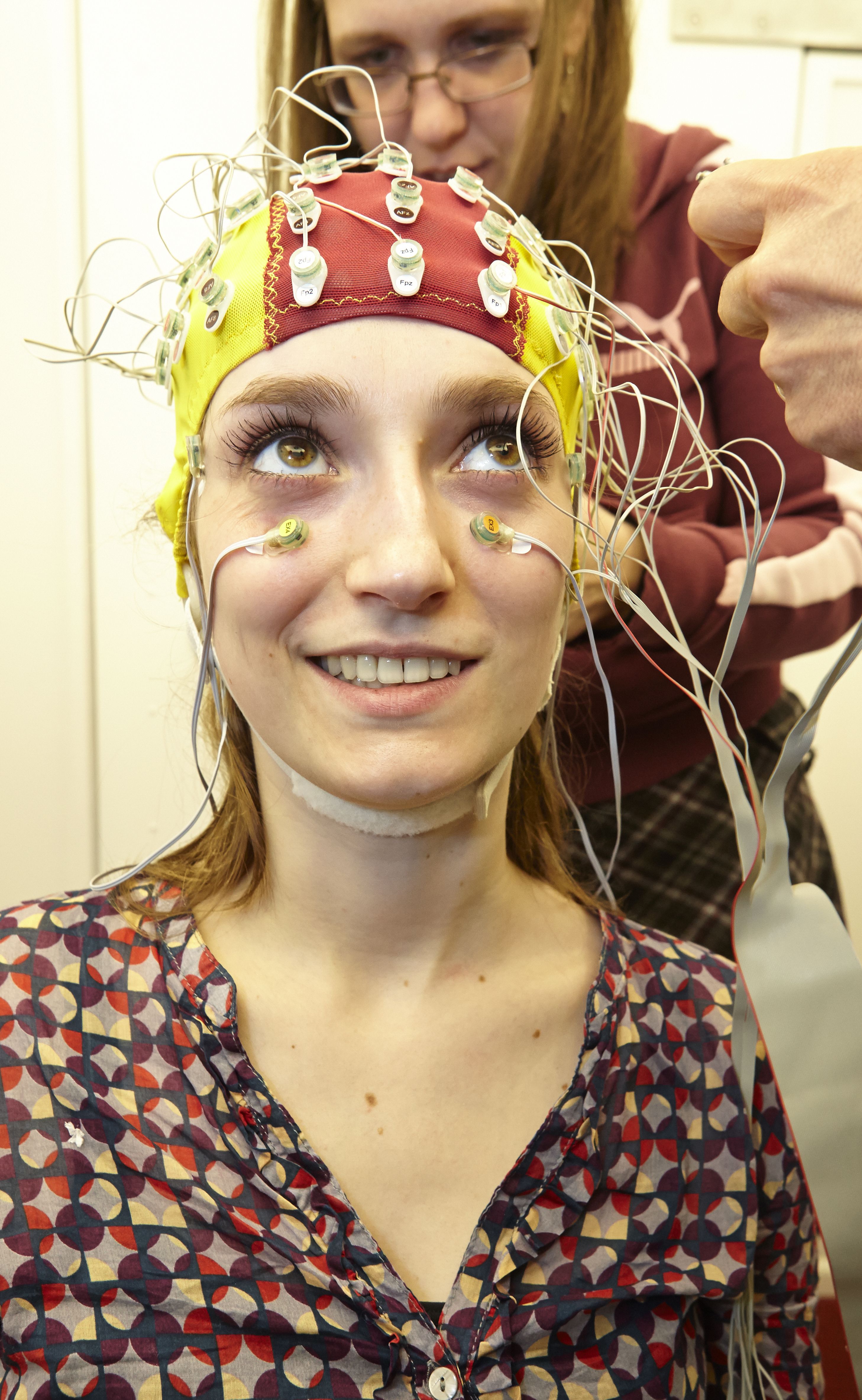 Photo of a student wearing an electrode fitted head cap with wires being connected to each electrode.