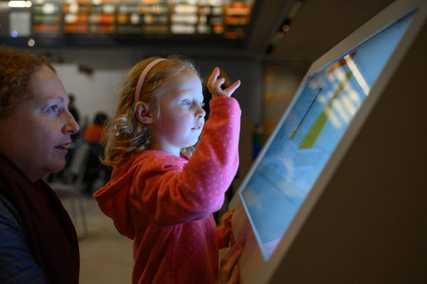 Child interacting with one of the digital displays during the  ‘Alice in Typhoidland’ exhibition
