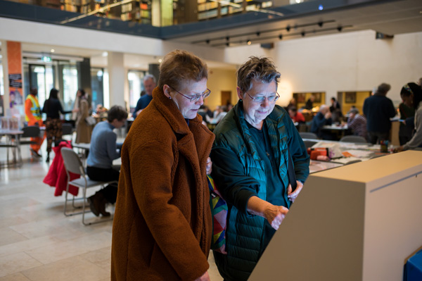 Visitors exploring a digital display at the  ‘Alice in Typhoidland’ exhibition