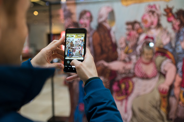 Visitor exploring displays via a phone app during the  ‘Alice in Typhoidland’ exhibition