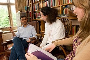 Photo of teacher and students conversing in a study