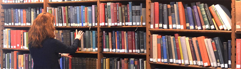 Library shelves with woman searching for book