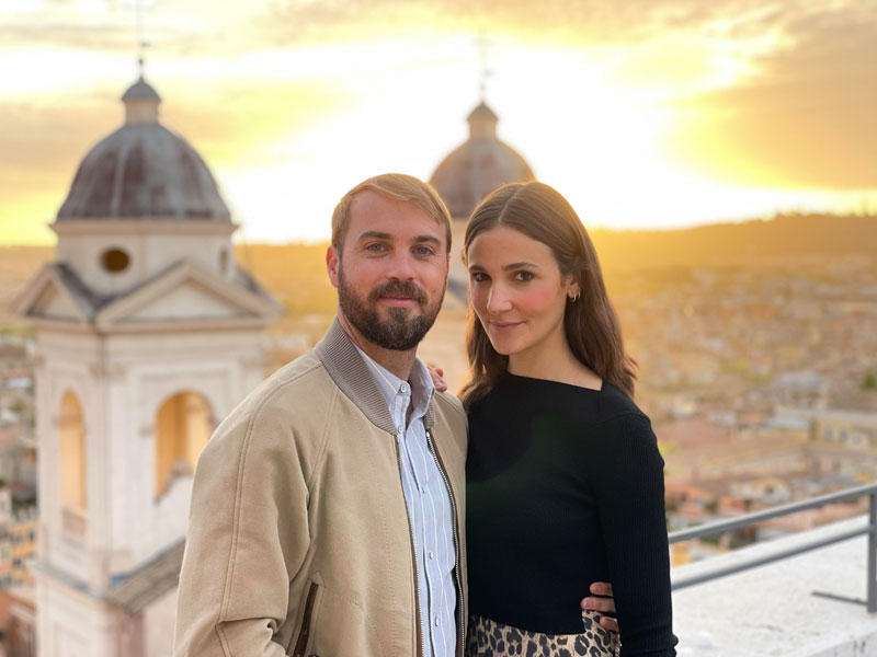 John and Alexandra Hering stand together against a sunset backdrop John and Alexandra Hering