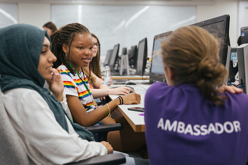 UNIQ student ambassador helping students in computer lab