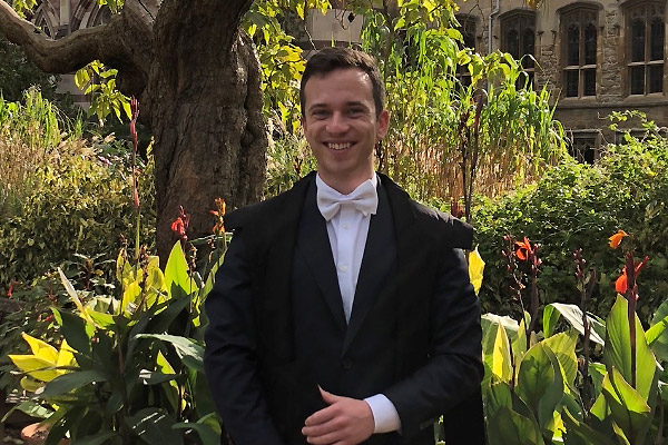 Saven Scholar Jan Berge dressed in sub fusc in the grounds of Balliol College in Oxford