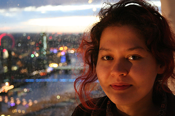 DeepMind Scholar Mizu-Nishikawa Toomey with a night-time city scape behind her