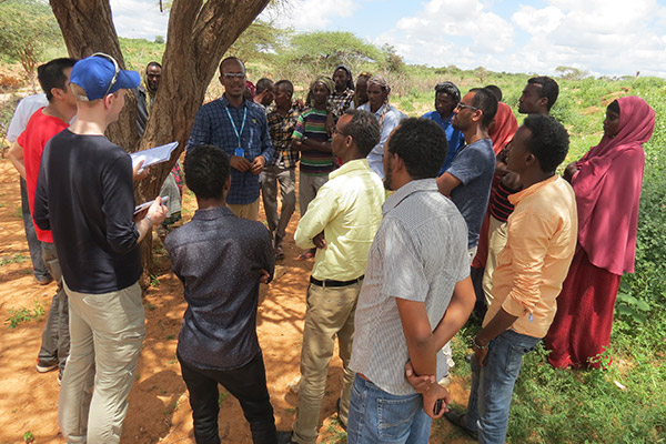 Alex Betts with about 20 refugees, standing in a circle around him, in the Dollo Ado refugee camps in Ethiopia