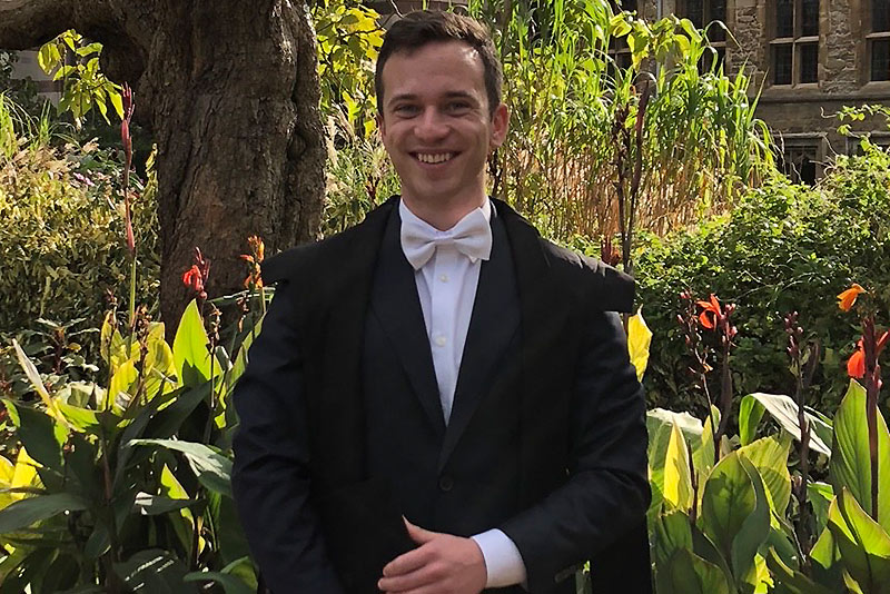 Saven Scholar Jan Berge dressed in sub fusc in the grounds of Balliol College in Oxford