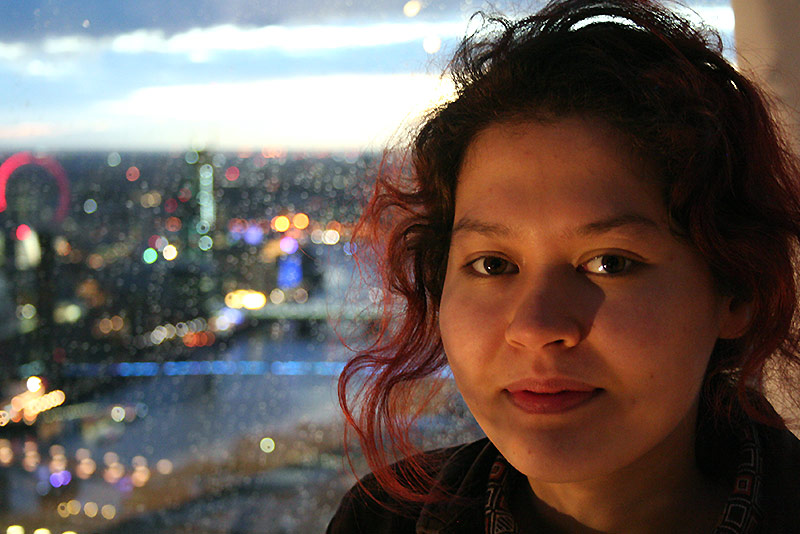 DeepMind Scholar Mizu-Nishikawa Toomey with a night-time city scape behind her