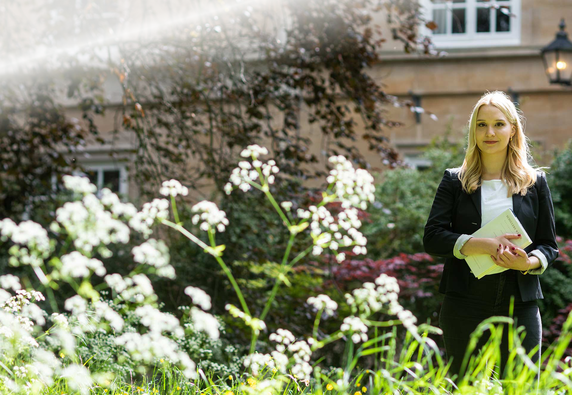 Sophie stands in the gardens of Balliol College on a sunny day.