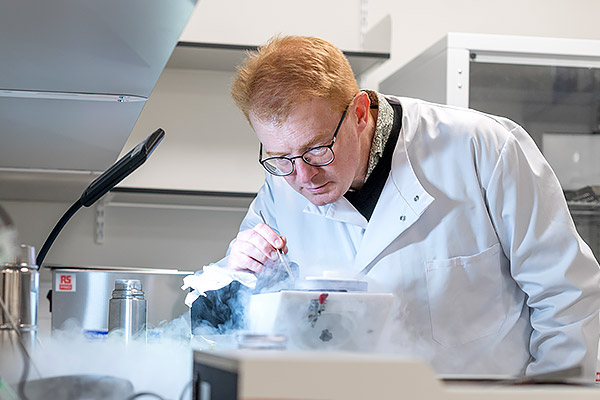 Professor Matt Higgins tends to an experiment in the lab. Vapour billows around the equipment he examines