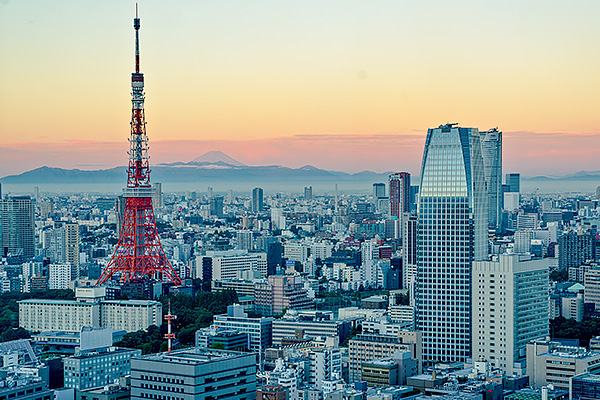 The glow of sunrise appears over the Tokyo skyline