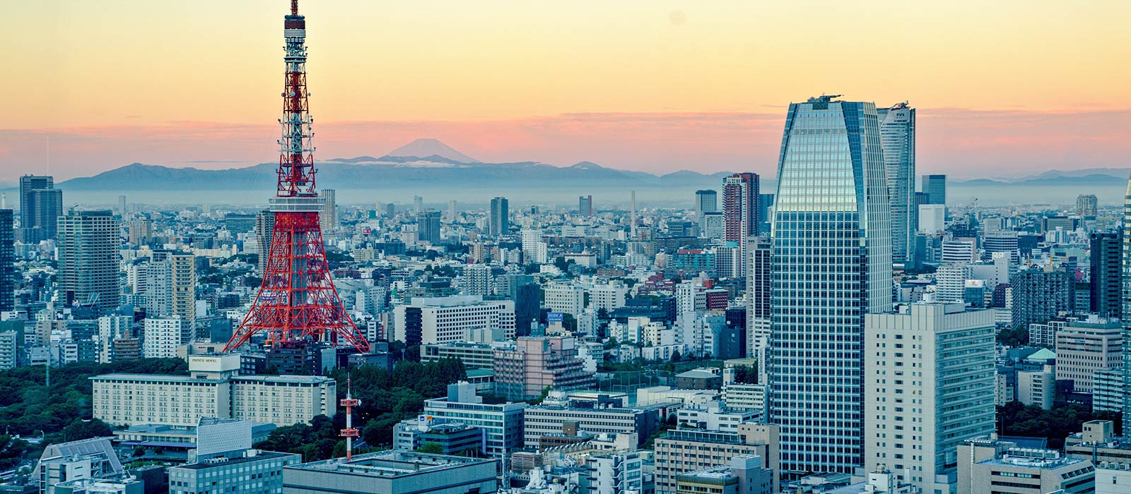 The glow of sunrise appears over the Tokyo skyline