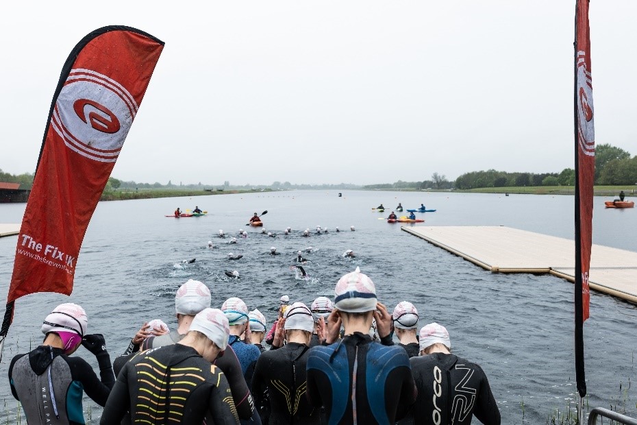 Triathletes entering a lake about to start a race