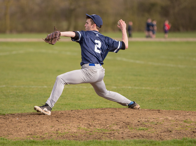 Close-up photo of a pitcher, mid-throw on the mound