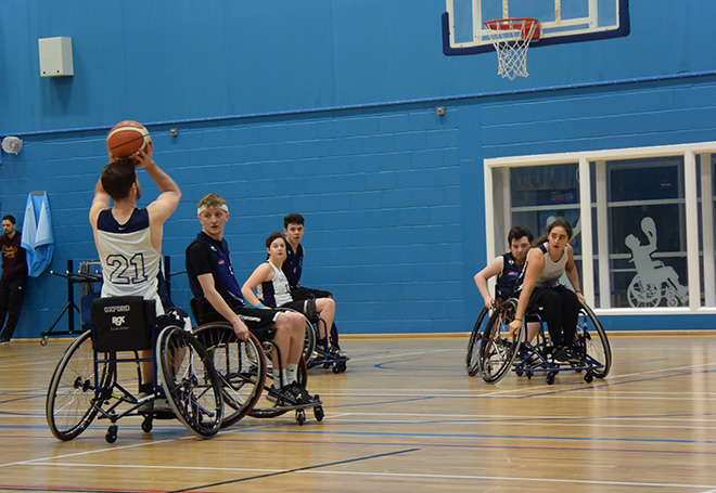 Photo of basketball player preparing for a 3-point shot in a wheelchair basket ball game