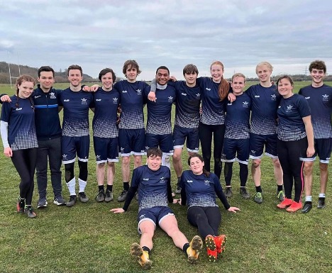 Fourteen players in Oxford dark blue kit take a team photo.